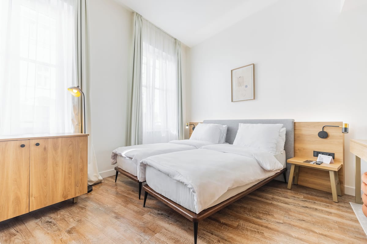 A double bed with a wooden headboard, a bedside table with a lamp, and a wardrobe with a mirror.