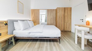 Un dormitorio moderno con cama, escritorio y silla.
