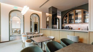 Un restaurante moderno con barra, mesas y sillas, y vistas a la cocina.