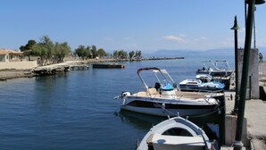 A marina with several boats docked, a clear sky, and a calm sea. - River Studios & Apartments (Corfu)