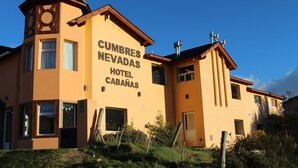 A hotel with a prominent sign reading "Cumbres Nevadas Hotel Cabanas." - Cumbres Nevadas - Hostería Boutique (El Chalten)