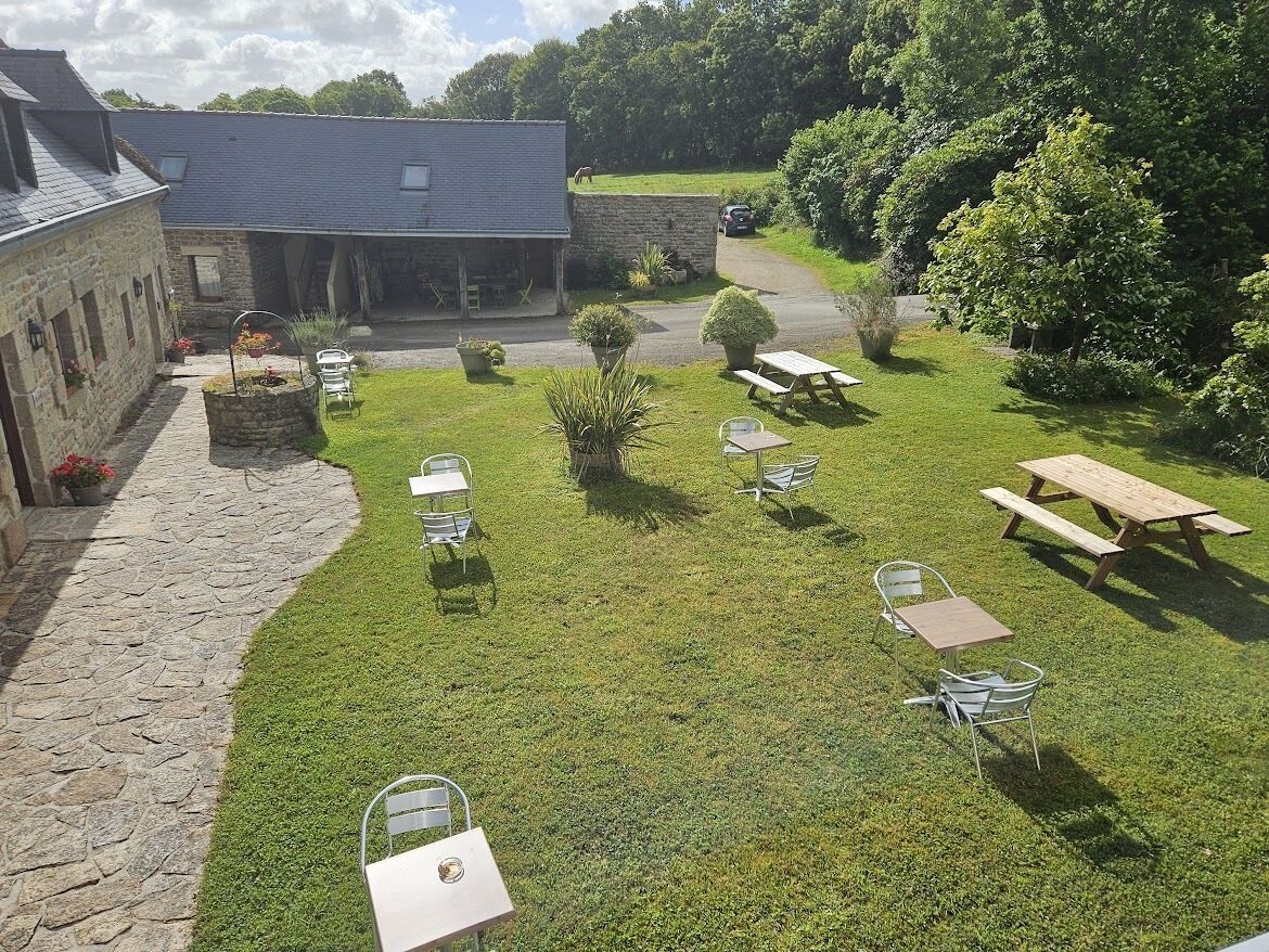 Een binnenplaats met stenen gebouwen, picknicktafels en stoelen.