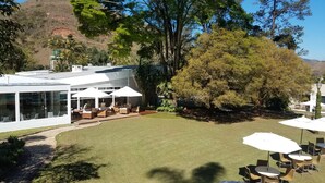 Una casa moderna con un patio amueblado con asientos y sombrillas.