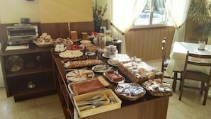 A buffet setup with various food items and a coffee machine. - Hotel Arboleda (Sanxenxo)