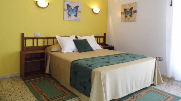 A bedroom with a bed, bedside tables, and wall-mounted light fixtures. - Hotel Arboleda (Sanxenxo)
