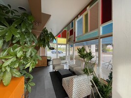 Un interior moderno con zona de estar, ventanas amplias y plantas de interior.