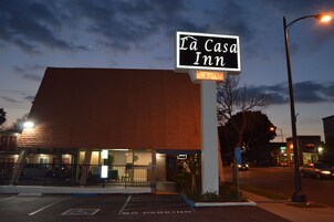 Un hotel llamado La Casa Inn con un cartel que indica habitaciones disponibles.