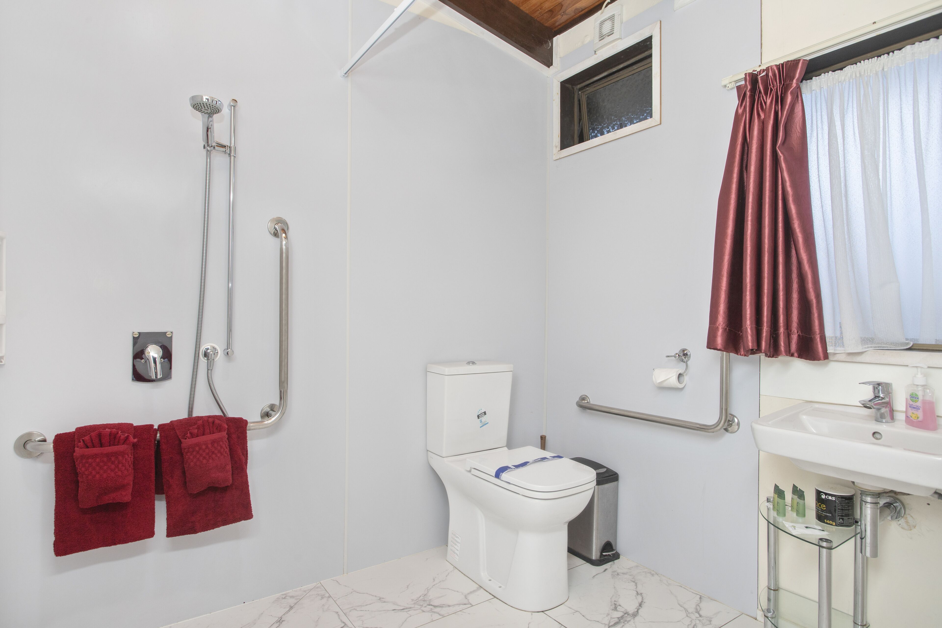 A bathroom with a shower, toilet, and sink.