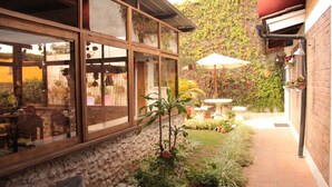 A courtyard with a patio area, potted plants, and a view of the surrounding landscape. - Dai Nonni Hotel (Guatemala City)