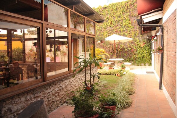 Un patio con zona de estar, plantas en macetas y vistas del paisaje circundante.