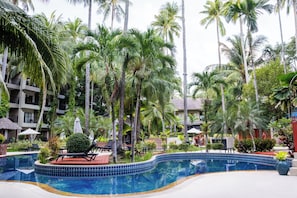 A resort with a swimming pool, palm trees, and lounge chairs. - Holiday Inn Resort Phuket Surin Beach by IHG (Choeng Thale)