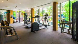 A gym with treadmills, elliptical machines, and weight benches.