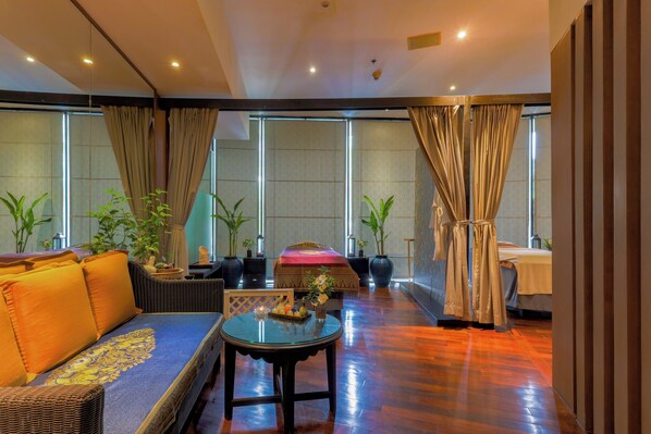 A spacious room with a large sofa, a round table, and a bed. There are potted plants and curtains. - Holiday Inn Resort Phuket Surin Beach by IHG (Choeng Thale)