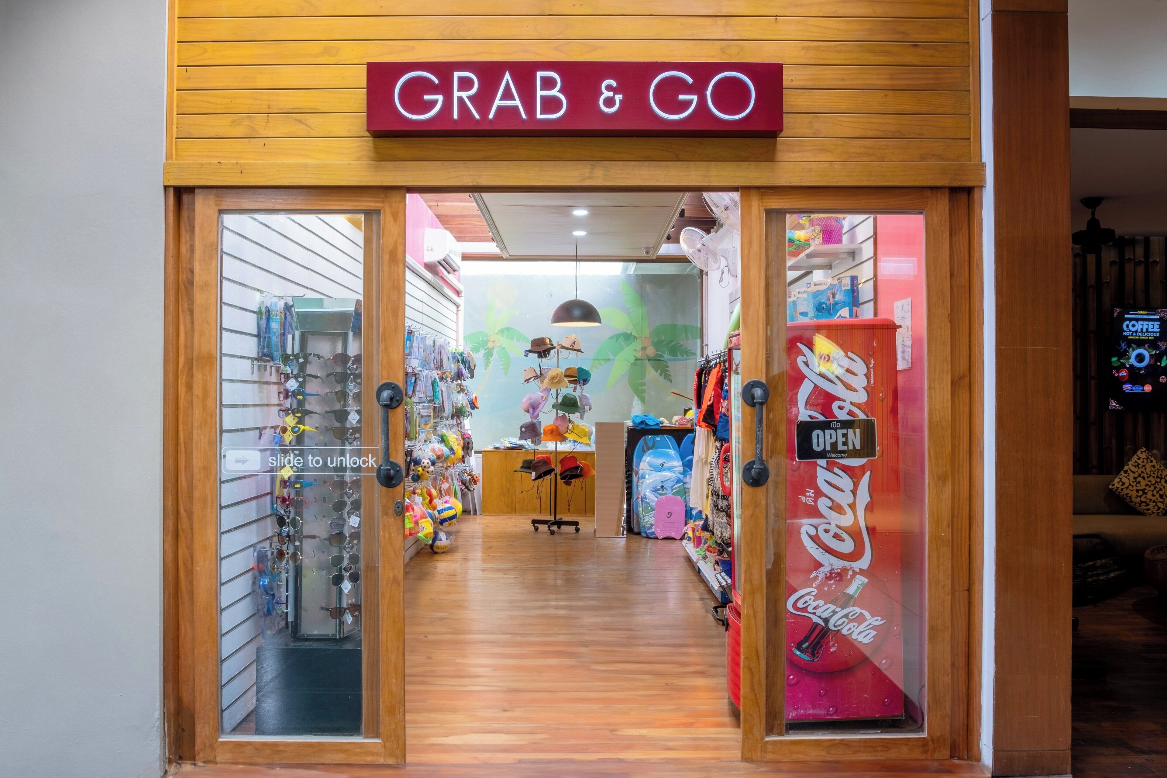 A storefront with a 'GRAB & GO' sign, a Coca-Cola refrigerator, and various items on display.
