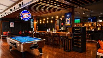 A billiards table, bar area, and seating with a pool table.