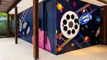 Un mur orné d’une fresque sur le thème de l’espace, comprenant une grande bobine de film et des planètes.