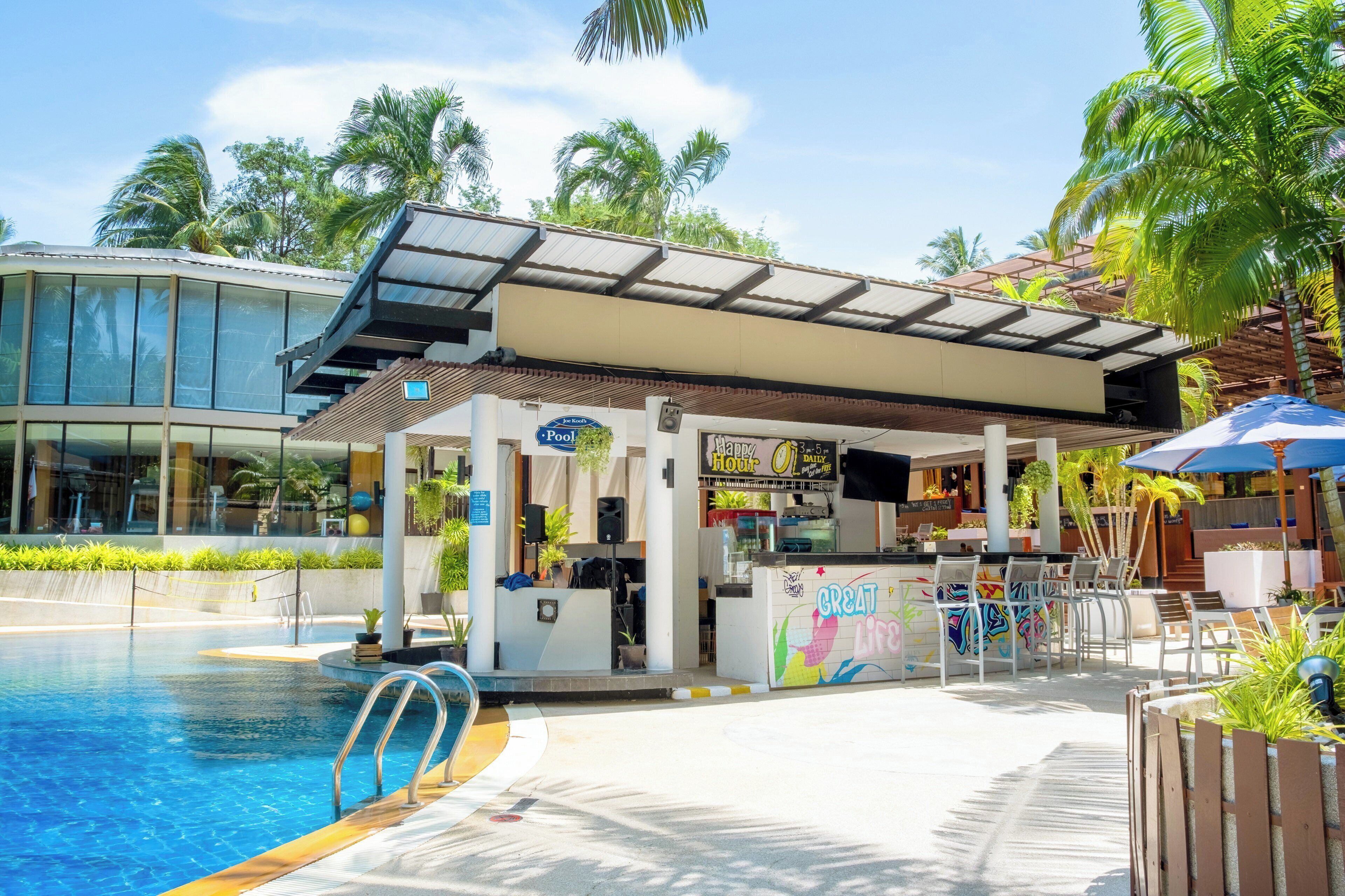 A poolside bar with a 'Happy Hour' sign, a pool, and a modern building with large windows.