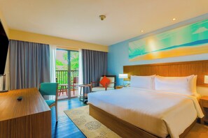 A hotel room with a large bed, a desk, a chair, and a view of the outdoors. - Holiday Inn Resort Phuket Surin Beach by IHG (Choeng Thale)