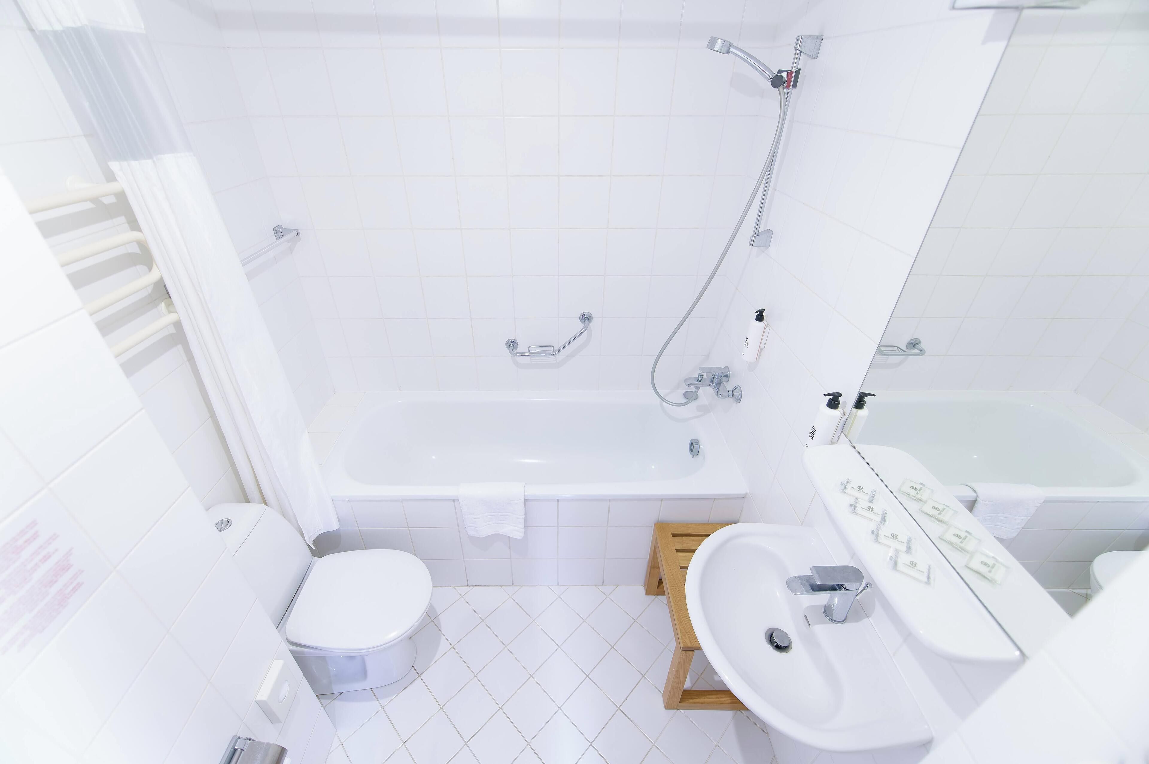 Een moderne badkamer met een bad, toilet en wastafel.