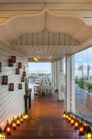 Un couloir doté d’un plancher en bois, de murs blancs et offrant une vue sur la mer.