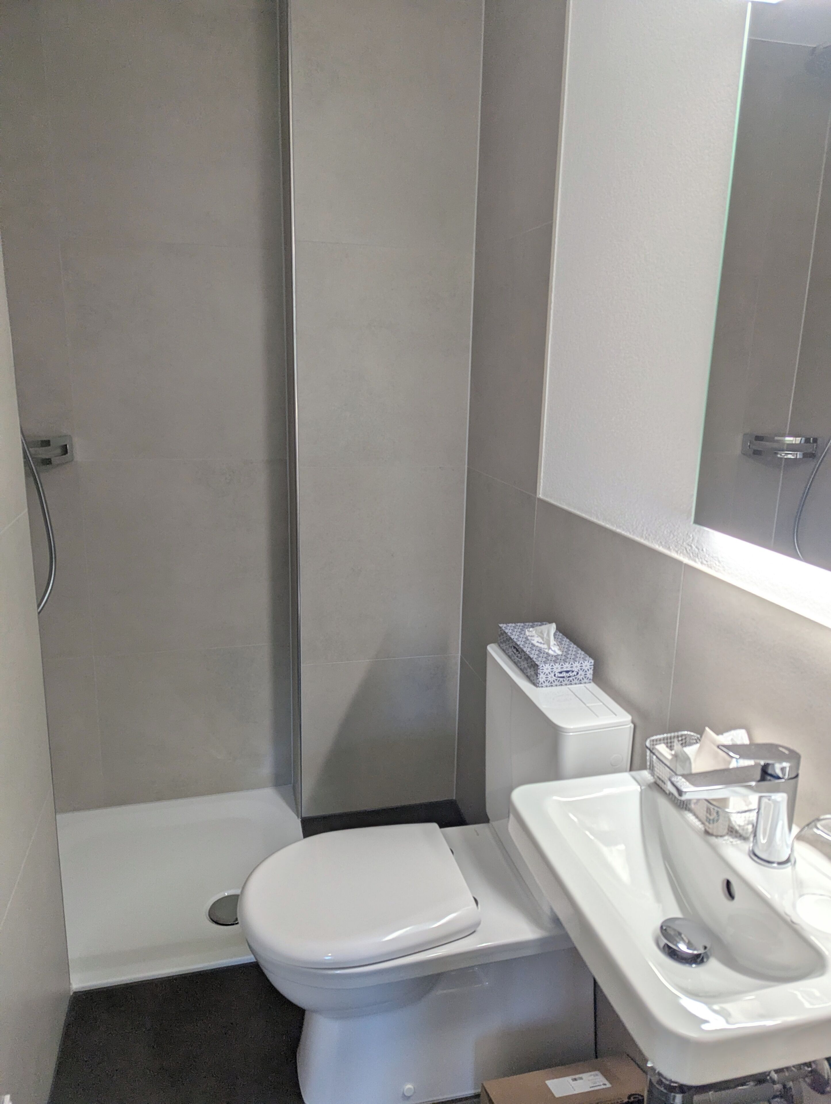 Une salle de bain avec des toilettes, un lavabo et une douche.
