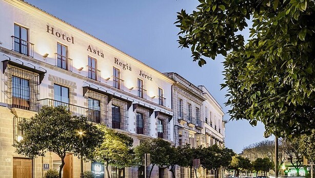 Een historisch pand met de naam "Hotel Astia Jerez" op de gevel, kenmerken­deks een klassieke architectuur met meerdere ramen en balkons.