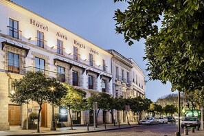 Um edifício histórico com a inscrição "Hotel Astia Jerez" na fachada, apresentando um estilo arquitetônico clássico, com várias janelas e varandas.