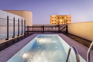 Una piscina al aire libre, sillones reclinables de piscina