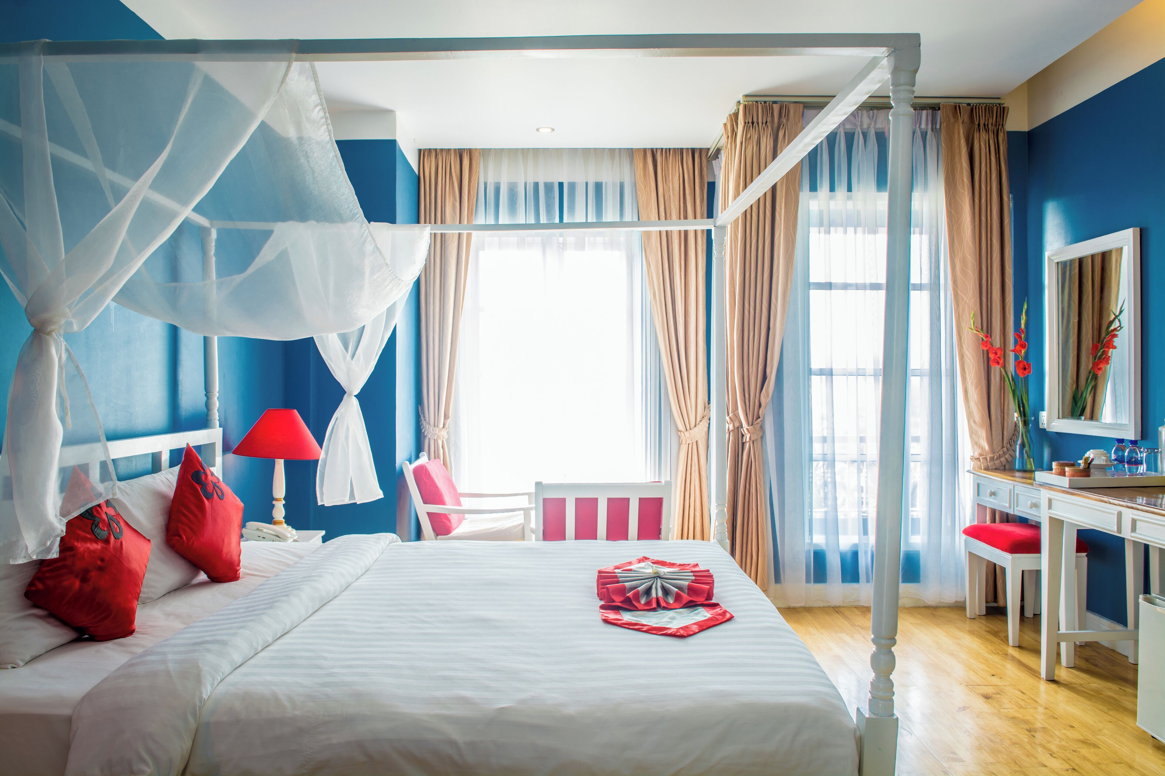 Un dormitorio con cama con dosel, un escritorio y una silla.