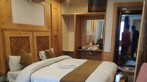 A wooden-framed bedroom with a bed, a mirror, and a walk-in closet. - Hotel SADAF (Srinagar)