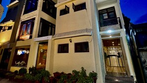 A multi-story hotel with a modern design, featuring balconies and a well-lit entrance. - Hotel SADAF (Srinagar)