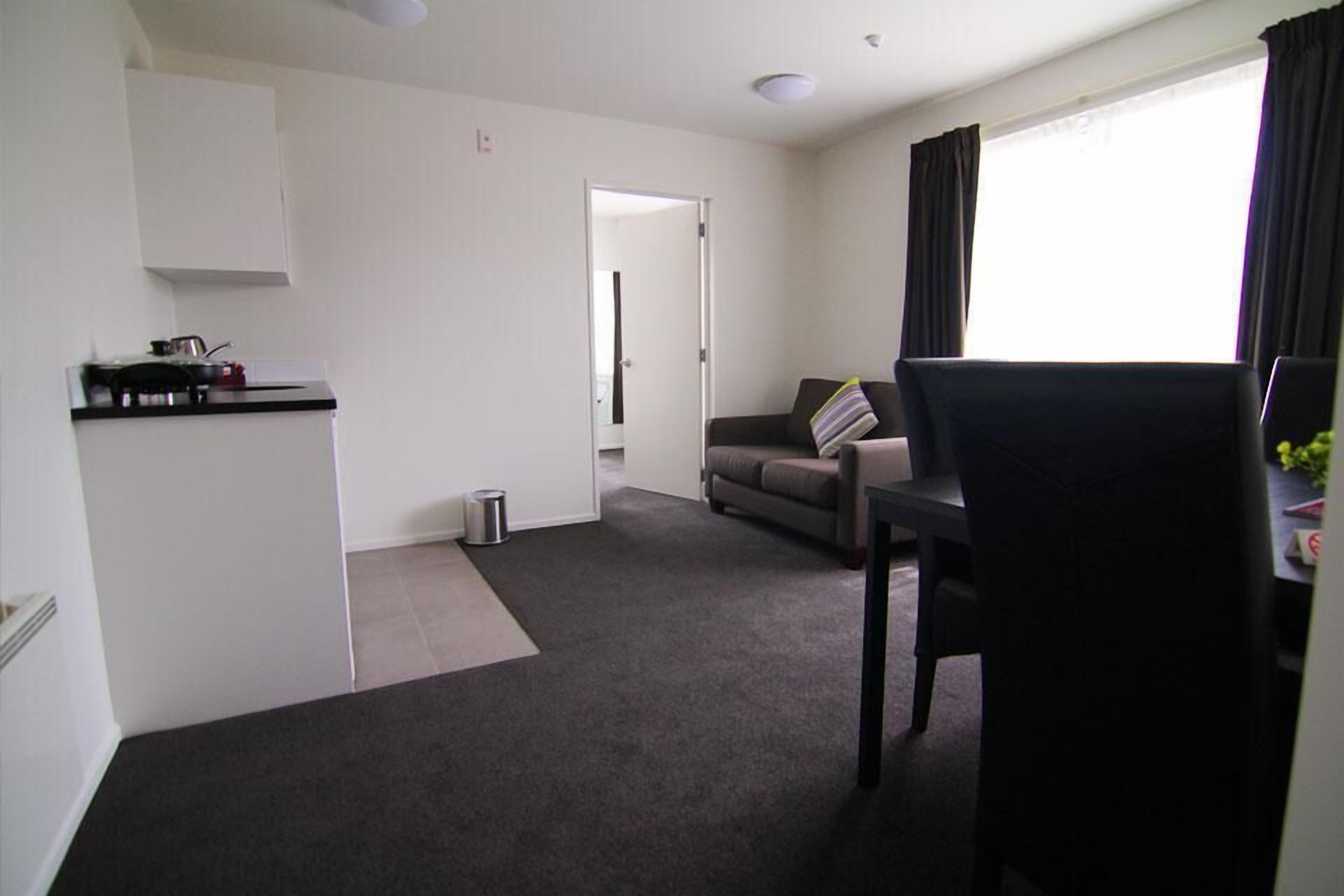 A compact living space with a kitchenette, a dining area, and a sofa.