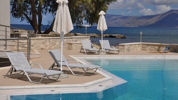 Piscine extérieure, parasols de plage, chaises longues