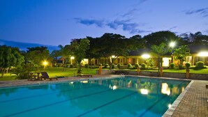 A swimming pool with lounge chairs and a well-maintained lawn area. - ANEW Resort White River Mbombela (Mbombela)