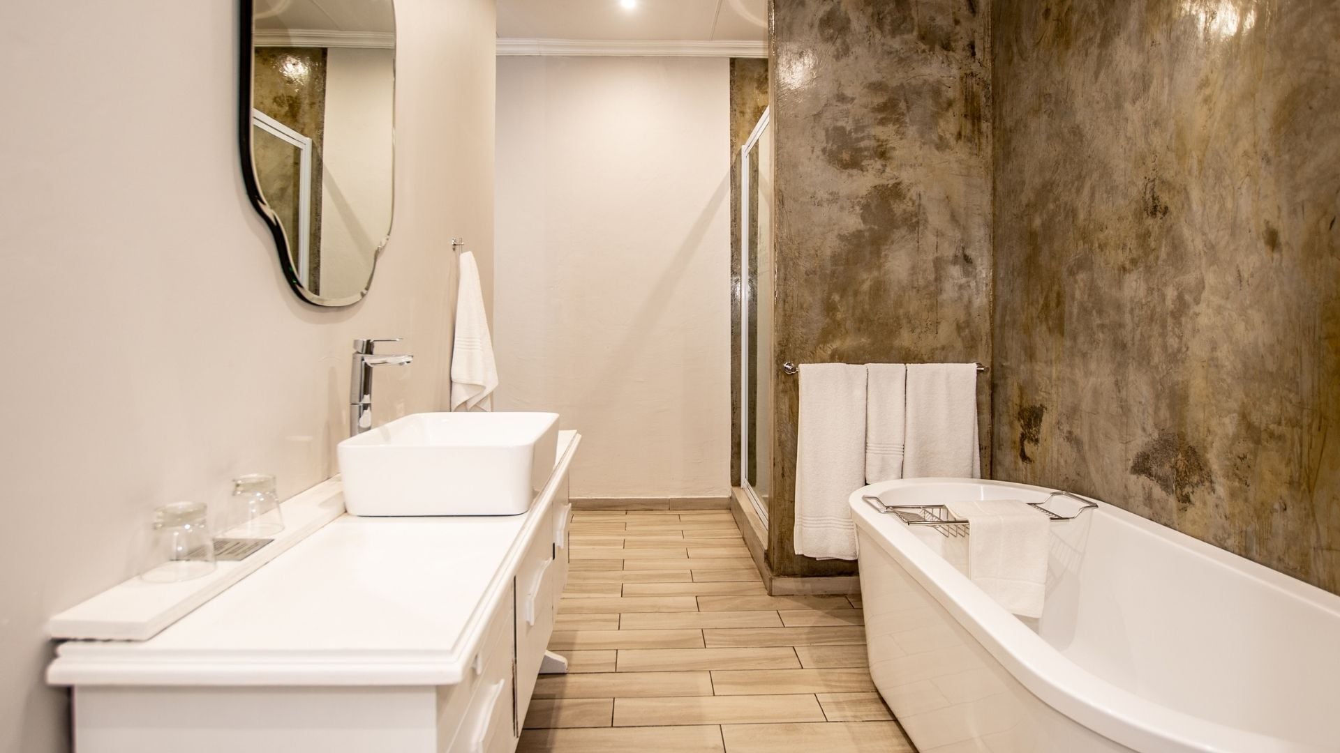 A modern bathroom with a large bathtub, a double sink vanity, and a shower area.