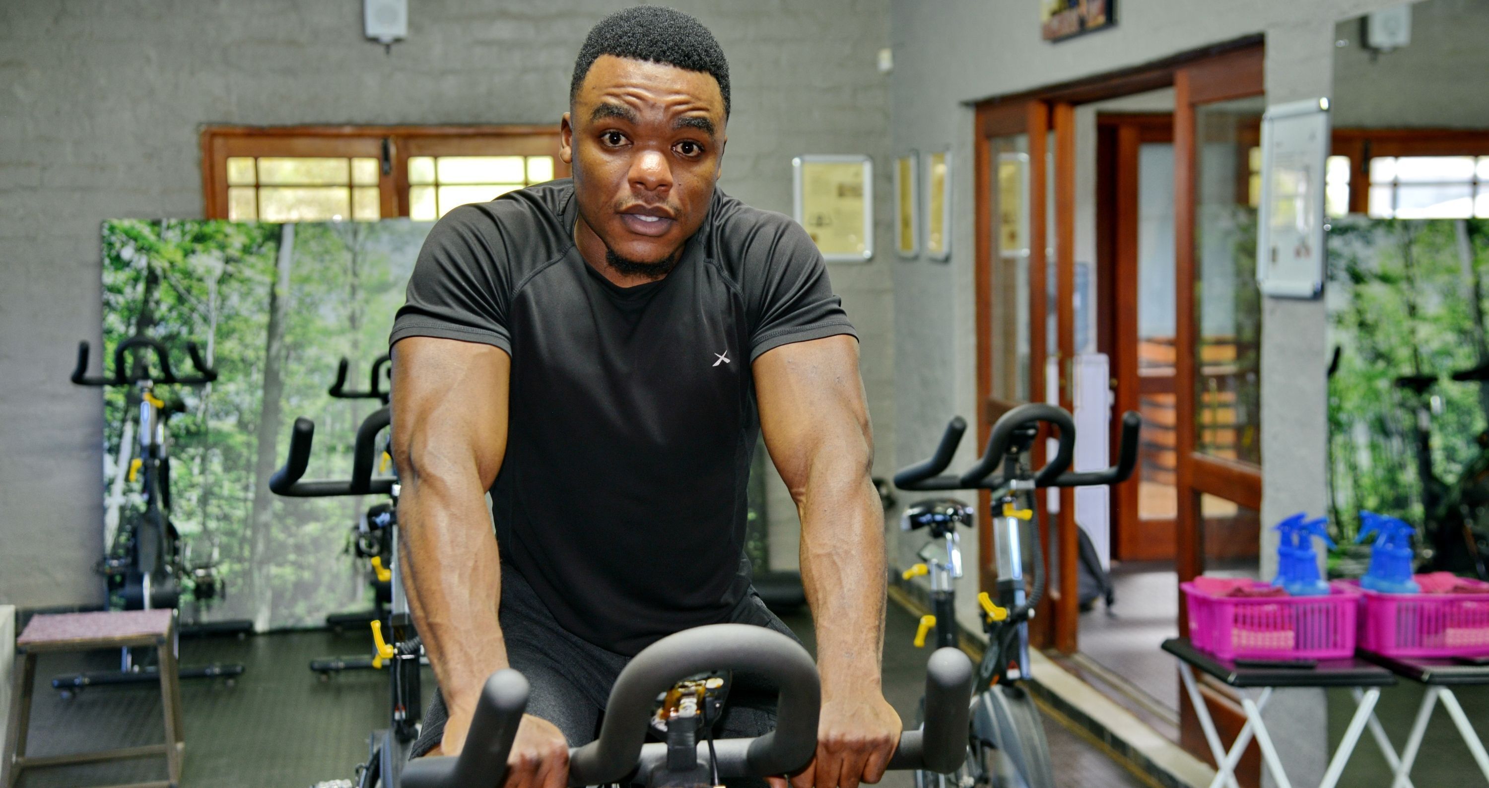 A gym with stationary bikes, exercise equipment, and a mirror.
