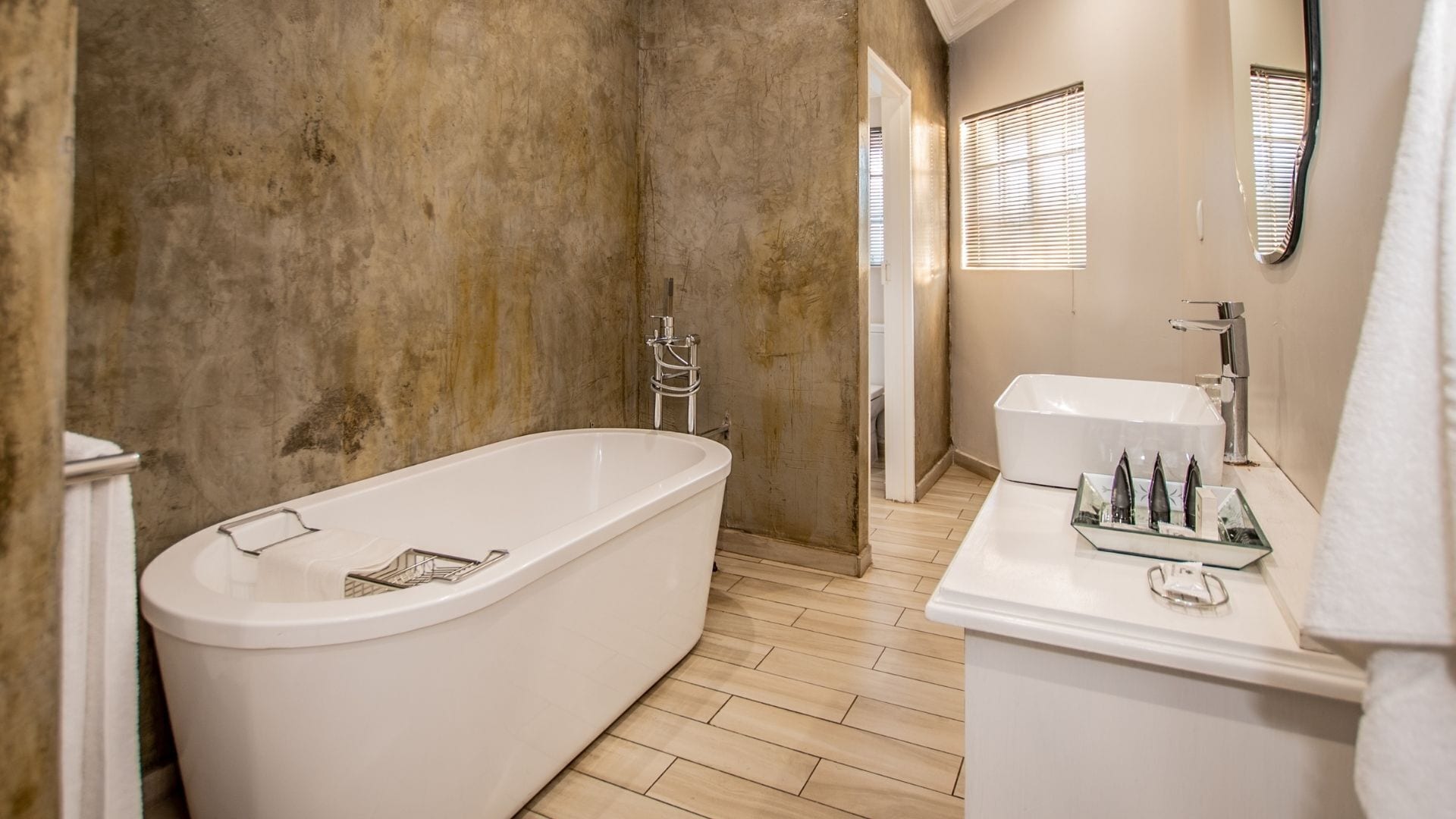 A modern bathroom with a freestanding bathtub, a separate sink area, and a shower.