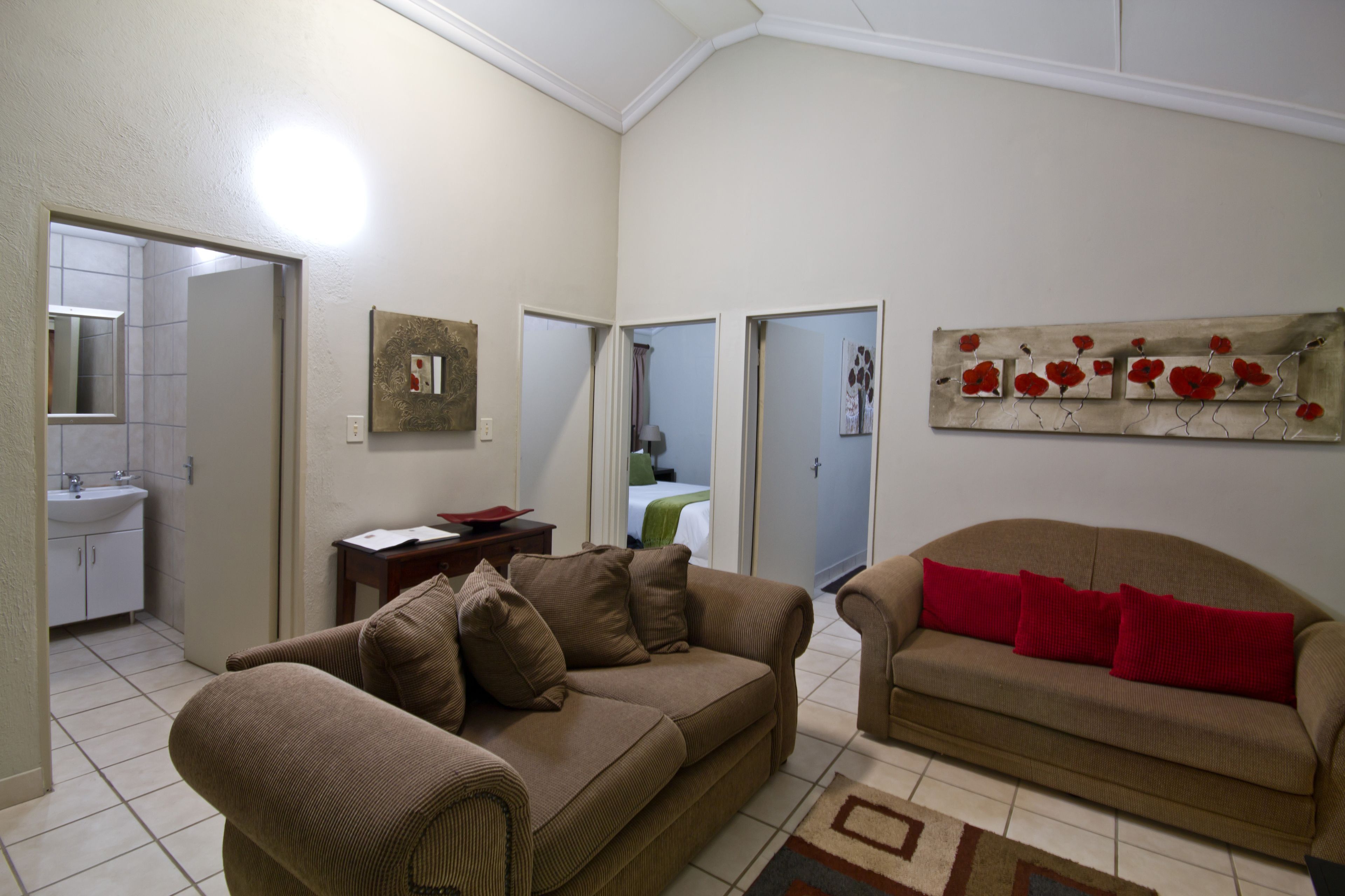 Una sala de estar con dos sofás marrones, una mesa de centro y un cuadro en la pared.