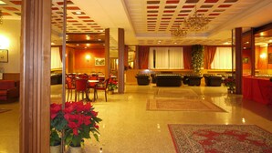 Een hotel lobby met een eetgedeelte, zitplaatsen en een kerstboom.