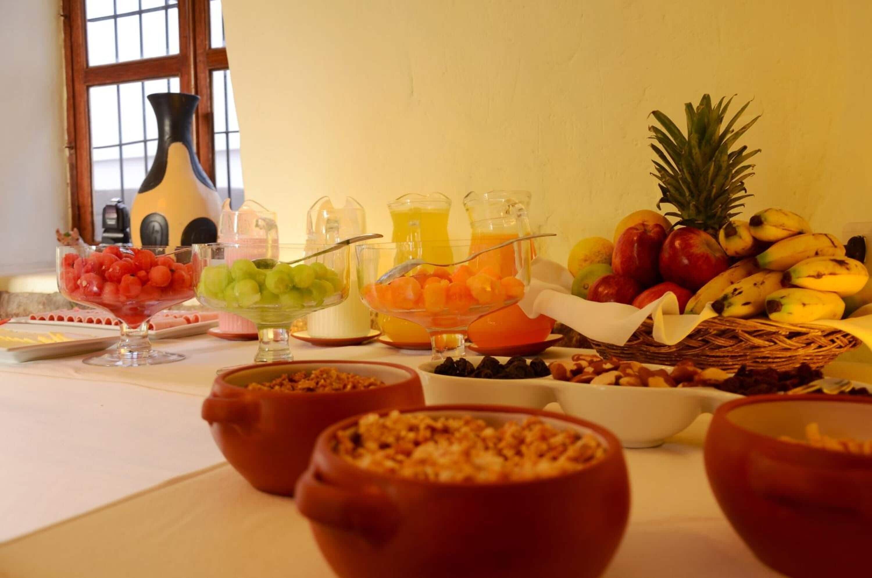 A breakfast buffet with various fruits, juices, and cereals.