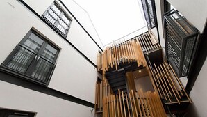 A modern building with a white facade, large windows, and a wooden balcony railing. - Destiny Scotland - The Malt House Apartments (Edinburgh)