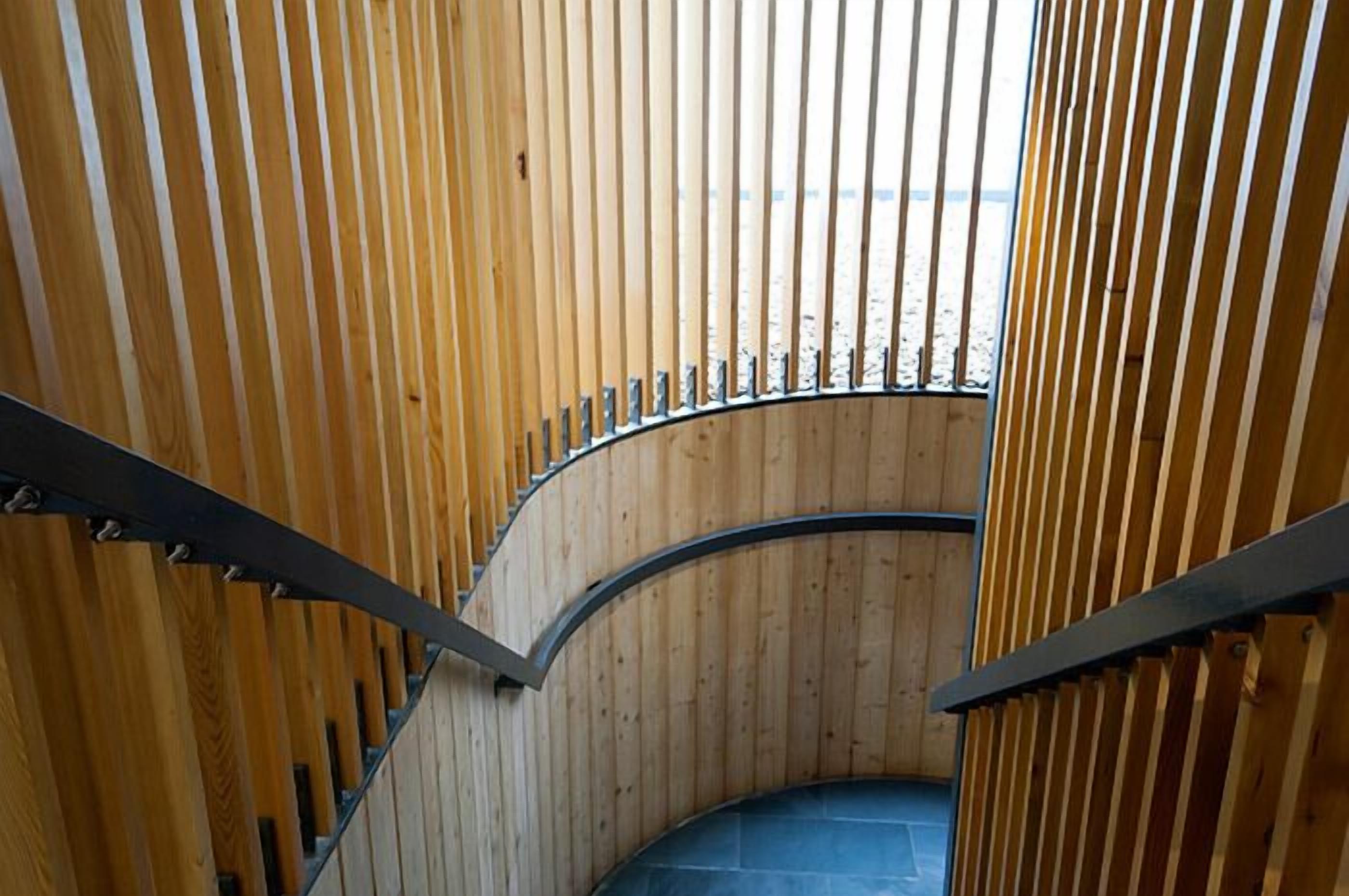 Eine Wendeltreppe mit Holzgeländern und einem geschwungenen Design.