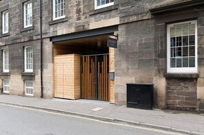 A building with a stone facade, a wooden entrance, and a sign indicating a hotel. - Destiny Scotland - The Malt House Apartments (Edinburgh)