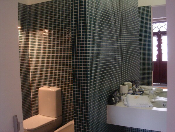 Un baño con inodoro, lavabo y espejo.