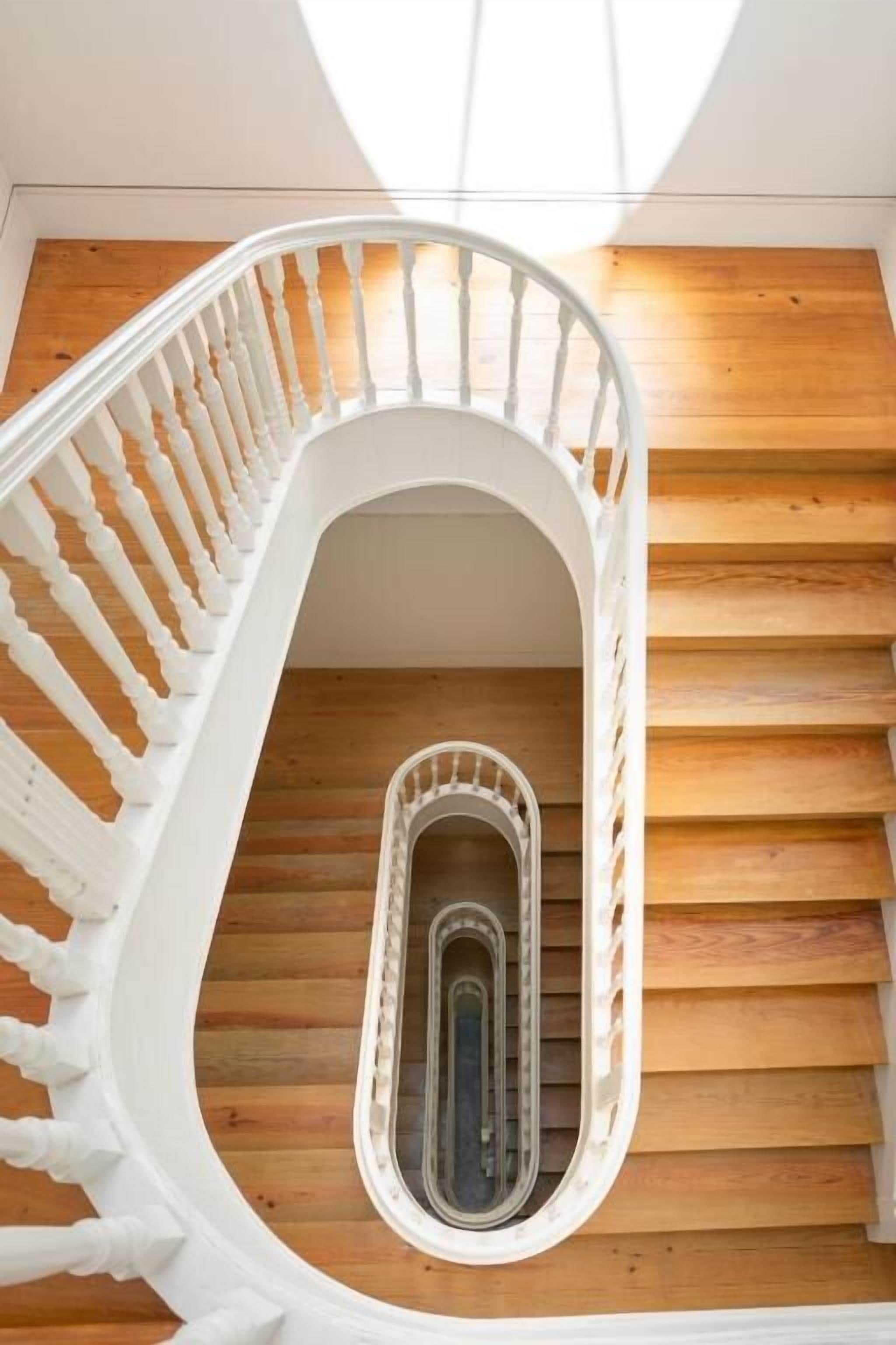 Eine Wendeltreppe mit weißen Balustraden und Holzbeschlägen.