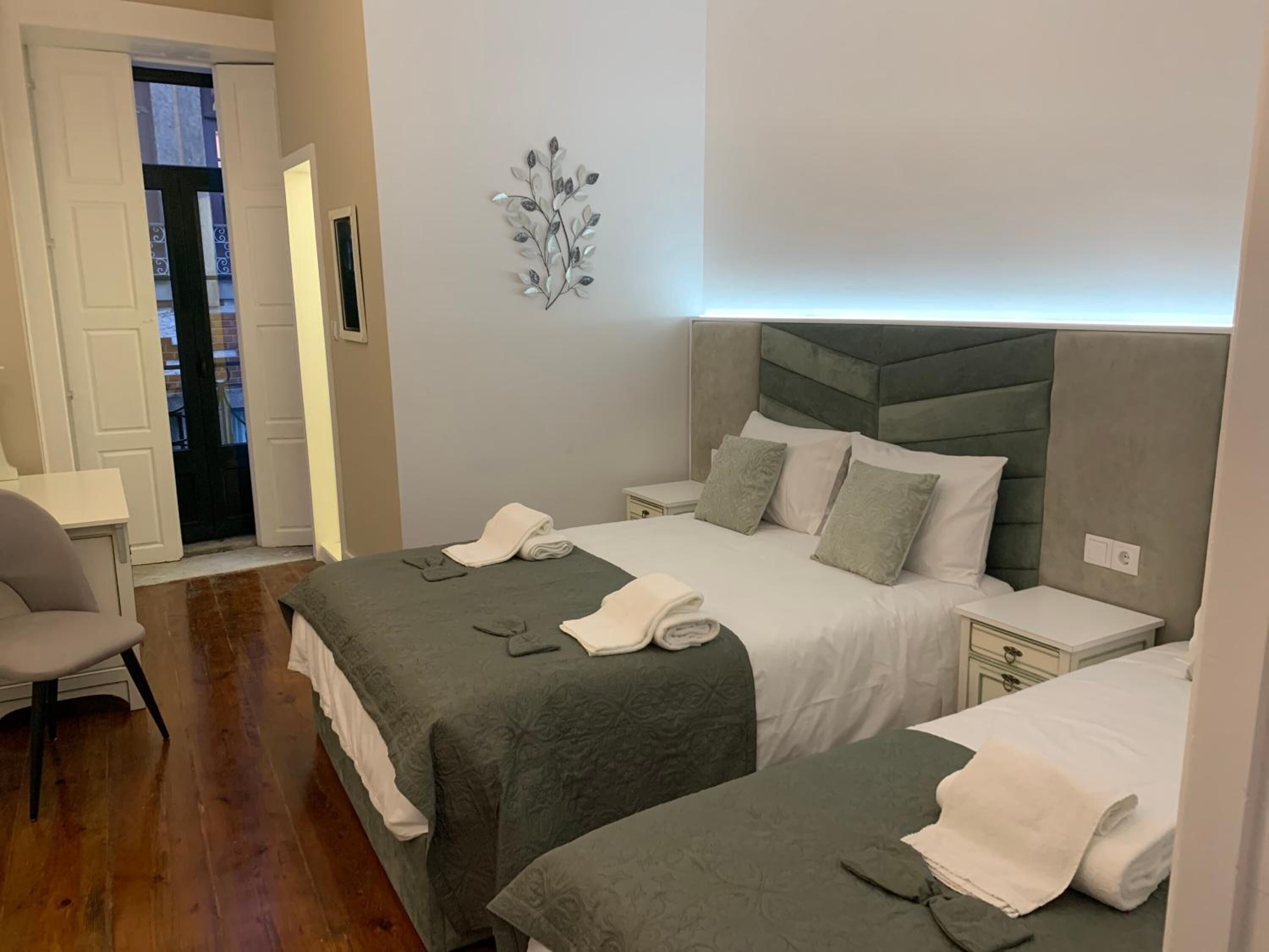 Camera d'albergo con due letti, una scrivania e una sedia.