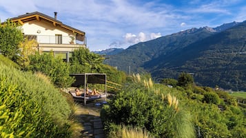 Une maison dotée d’un balcon donnant sur un paysage montagneux.