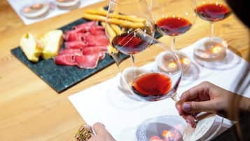 Une table avec un verre de vin rouge, une assiette de viande tranchée et une assiette de frites.