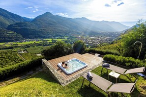 A hot tub on a wooden deck with a view of a valley and mountains. - Wine Hotel Retici Balzi (Poggiridenti)