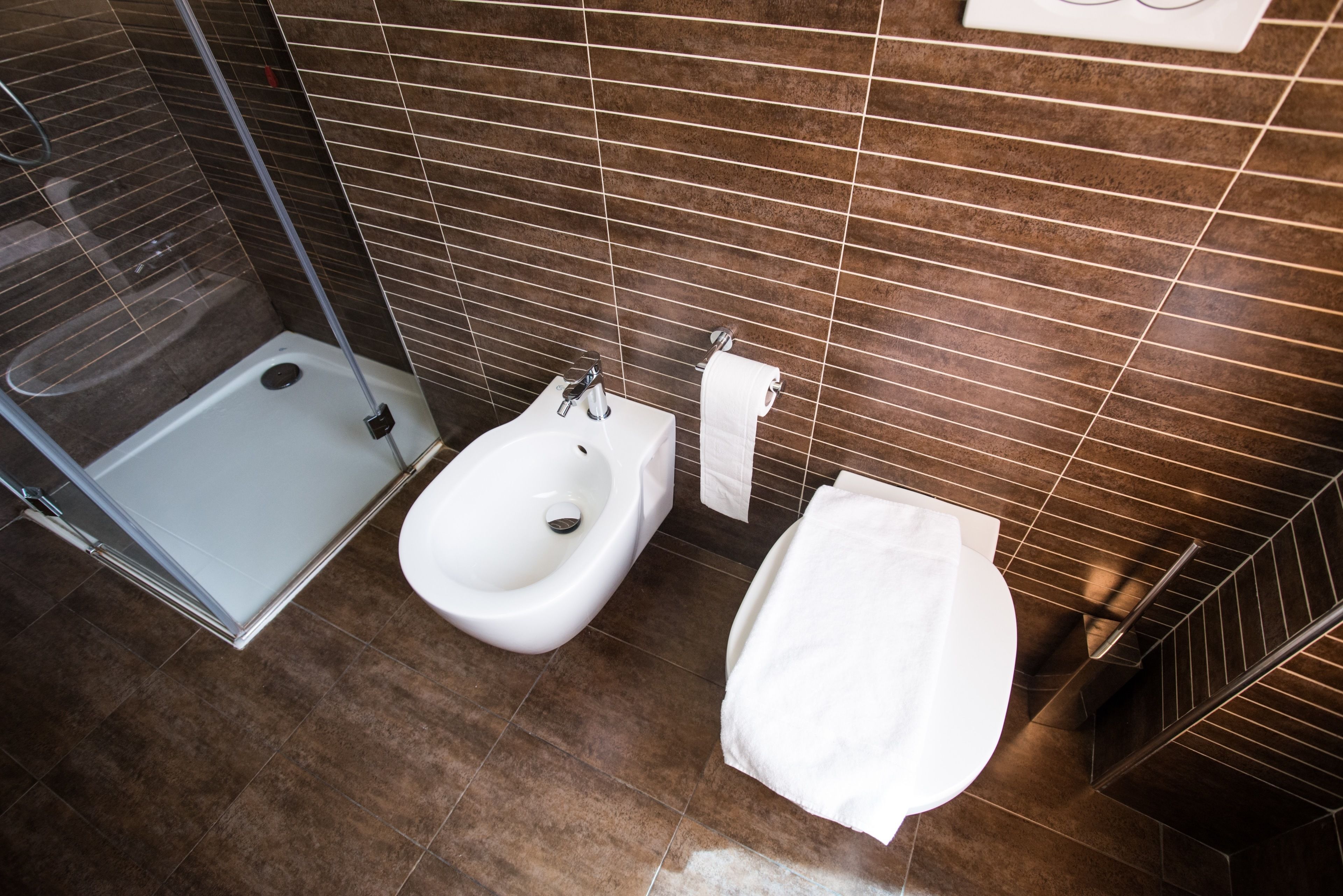 Une salle de bain moderne avec une douche à parois de verre, un bidet et des toilettes.